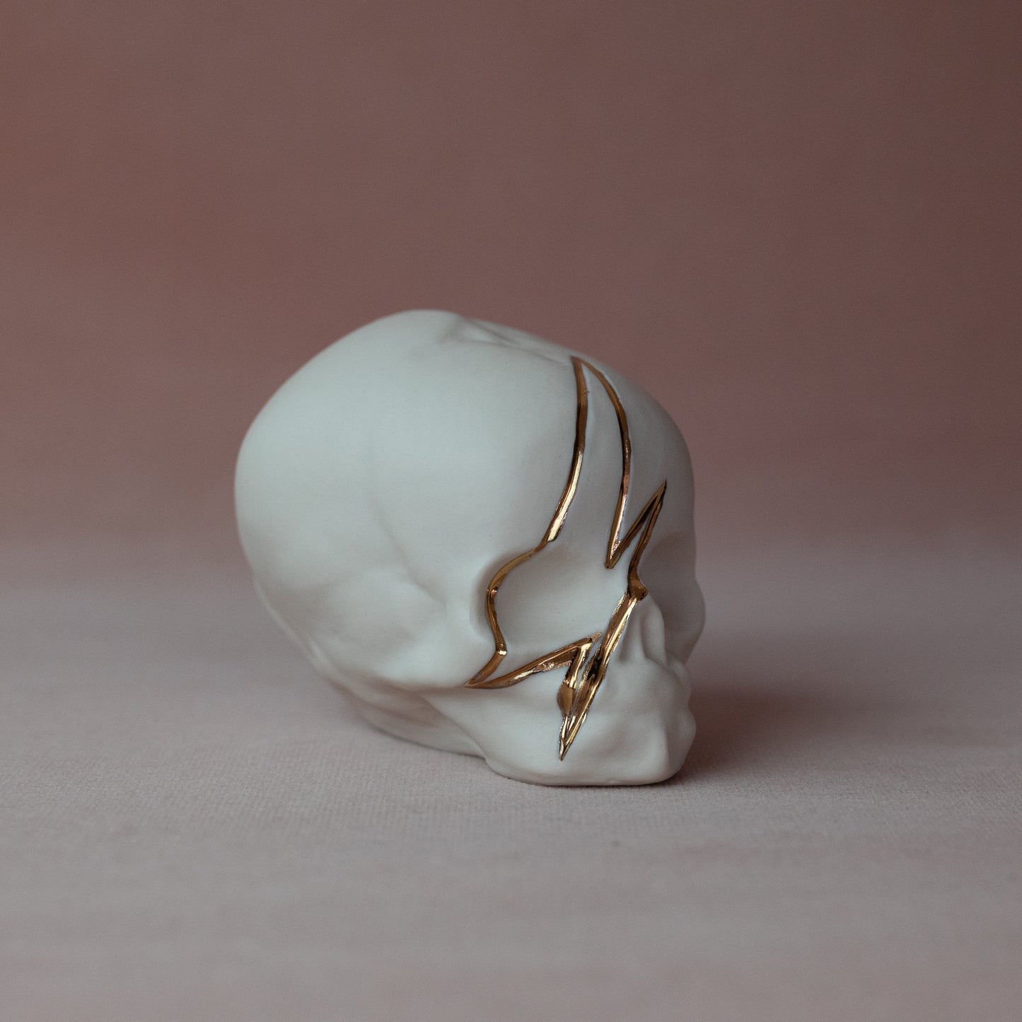 Gilded Porcelain Skull with Lighting Bolt